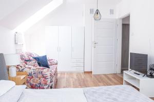 a bedroom with a bed and a couch and a tv at Apartament Piastowska in Olsztyn