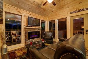 ein Wohnzimmer mit einem Ledersofa und einem Kamin in der Unterkunft A Cozy Mountain Hideaway - 1 Bedrooms, 1 Baths, Sleeps 4 cabin in Sevierville