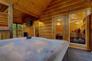 einen großen Whirlpool in einem Zimmer mit Holzwänden in der Unterkunft A Cozy Mountain Hideaway - 1 Bedrooms, 1 Baths, Sleeps 4 cabin in Sevierville
