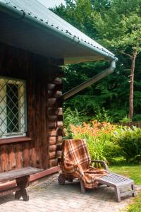 una mecedora sentada fuera de una cabaña de madera en Ptasi Śpiew, en Futoma