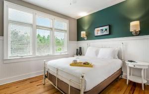 a bedroom with a large white bed with green walls at Eagle Cottages at Gulf State Park in Gulf Shores +20 photos