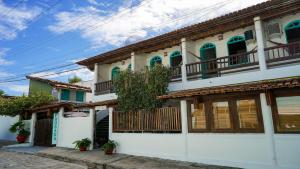 una casa bianca con balconi su una strada di Pousada Coração do Arraial a Arraial d'Ajuda