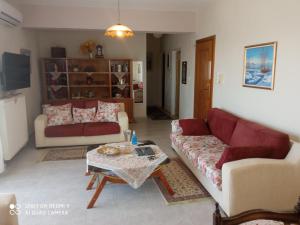 a living room with two couches and a coffee table at BELLA-CAZA in Makri