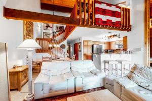 a living room with a white couch and a kitchen at Elkhorn Retreat in Sun Valley