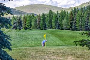 a man standing on a golf course with a yellow flag at Elkhorn Retreat in Sun Valley