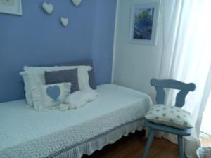 a blue bedroom with a bed and a chair at B&B Il Giullare in Sulmona