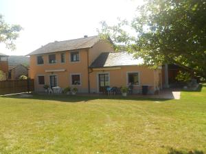 ein gelbes Haus mit einem Garten mit Stühlen und Tischen in der Unterkunft Apartamentos rurales Casa Rosi in Ranón
