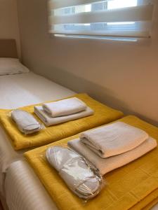 two beds with towels on them in a bedroom at Apartments Radulovic in Petrovac na Moru