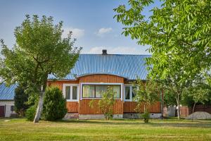 una casa con techo de estaño azul en ROZTOCZE Wiejski Domek, en Horyniec