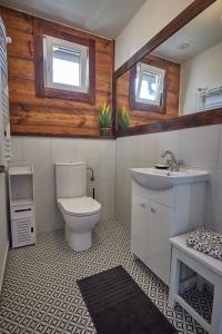 La salle de bains est pourvue de toilettes, d'un lavabo et de 2 fenêtres. dans l'établissement ROZTOCZE Wiejski Domek, à Horyniec