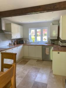 a kitchen with white cabinets and a sink at Honeysuckle Cottage in Hereford