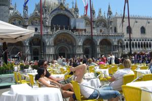 un gruppo di persone seduti ai tavoli di fronte a un edificio di Casa Torretta a Venezia