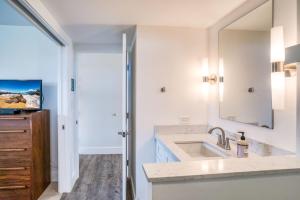 un baño con lavabo y espejo en Sugar Beach 502 condo, en Kihei 11 fotos más