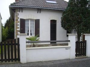 a white house with a black and white fence at maison à 400 mètres de la plage in La Baule