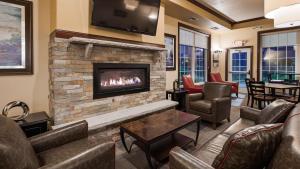 a living room with couches and a fireplace at Best Western Plus Wausau-Rothschild Hotel in Rothschild