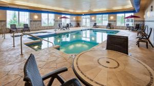 una piscina con mesa y sillas en una habitación de hotel en Best Western Plus Wausau-Rothschild Hotel, en Rothschild