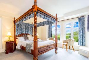 a bedroom with a four poster bed and a window at Best Western Limpley Stoke Hotel in Bath