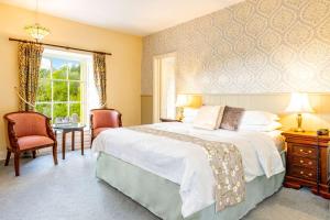 a bedroom with a bed and a desk and a window at Best Western Limpley Stoke Hotel in Bath