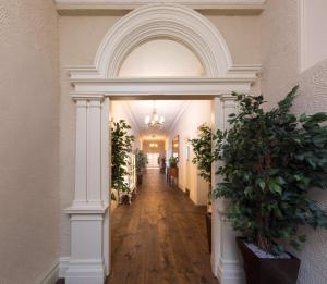 a hallway with an archway in a building with potted plants at Best Western Walton Park Hotel in Clevedon