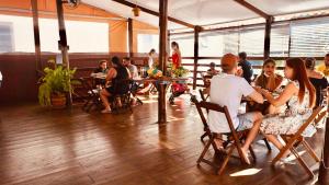 a group of people sitting in chairs in a restaurant at Beija Flor Pousada in Ubatuba +29 photos