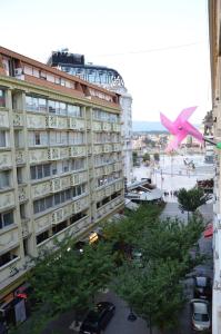 Ein großes rosafarbenes Flugzeug fliegt über ein Gebäude in der Unterkunft Ars Square Apartments in Skopje