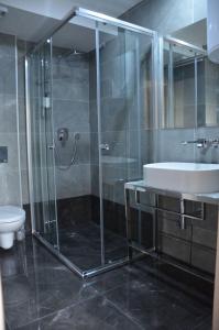 ein Bad mit einer Dusche, einem Waschbecken und einem WC in der Unterkunft Ars Square Apartments in Skopje