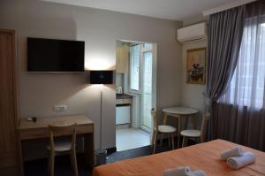 a hotel room with a bed and a desk and a kitchen at Ars Square Apartments in Skopje