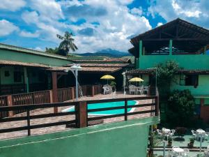 a house with a deck and a swimming pool at Pousada Campo Alegre in Itatiaia