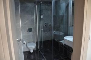 a bathroom with a shower with a toilet and a sink at Ars Square Apartments in Skopje