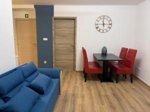 a living room with a blue couch and a table at Gîtes de la Croisette 2 in Dinant +6 photos
