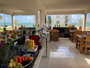a restaurant with tables and chairs with food on display at Pousada A Casa Portuguesa in Cabo de Santo Agostinho