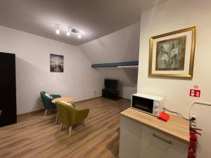 a living room with a tv and chairs in a room at Gîtes de la Croisette 3 in Dinant