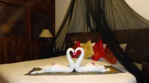 two swans making a heart sign on a bed at Posada Casa Adriana in Puerto Vallarta +41 photos