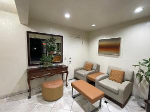 a living room with two chairs and a piano at Sierra Inn in South El Monte