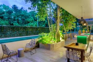 a patio with a table and chairs and a pool at Private pool apartment for groups in Tulum