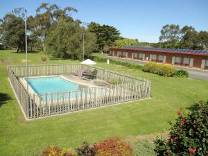 a fence around a swimming pool in a yard at Tarra Motel in Yarram
