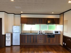 a kitchen with wooden cabinets and a white refrigerator at New Open!!! BRIDGE 小浜島 in Kohama