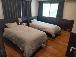 two beds in a hotel room with a window at New Open!!! BRIDGE 小浜島 in Kohama