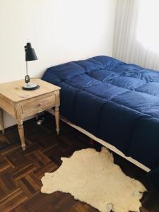 1 dormitorio con 1 cama y 1 mesa con lámpara en Penthouse Malva Rosa, en Montevideo