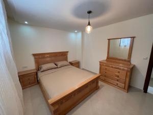 um quarto com uma cama, uma cómoda e um espelho em Residence Akodad em Al Hoceïma