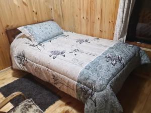 1 cama con edredón azul y blanco y almohada en Montblanc, en Las Trancas