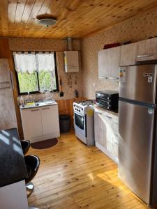 a kitchen with a stainless steel refrigerator and wooden floors at Montblanc in Las Trancas