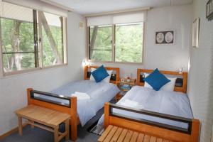Postel nebo postele na pokoji v ubytování Myoko Mountain Lodge