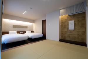 1 dormitorio con 2 camas y pared en Hotel Celeste Shizuoka en Shizuoka