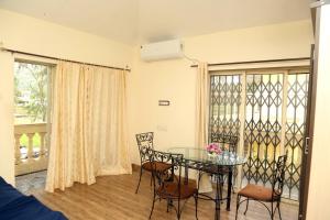 a dining room with a glass table and chairs at Satyam Villa 5Bhk Lonavala in Lonavala