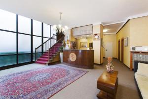 a living room with a staircase and a large window at Hotel Excelsior Pavia in Pavia