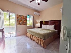a bedroom with a bed and a large window at BELIZE TROPICAL DREAM VILLAS in San Pedro