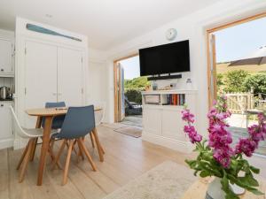 a kitchen and dining room with a table and a tv at 2 Garden Apartment in Kingsbridge