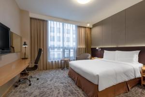 a hotel room with a large bed and a desk at LeafIN Hotel Beijing Minzuyuan l Bird's Nest in Beijing +24 photos