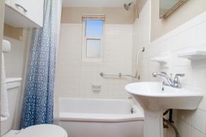 uma casa de banho branca com um lavatório e um WC em Tropic Terrace #23 - Beachfront Rental condo em St. Pete Beach